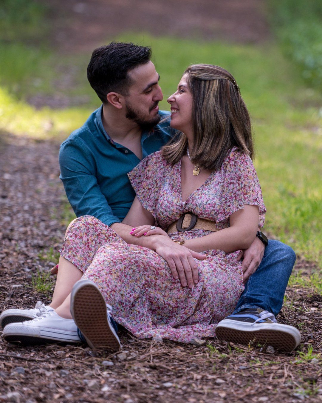 Casal sentado no jardim durante a sessão de noivos